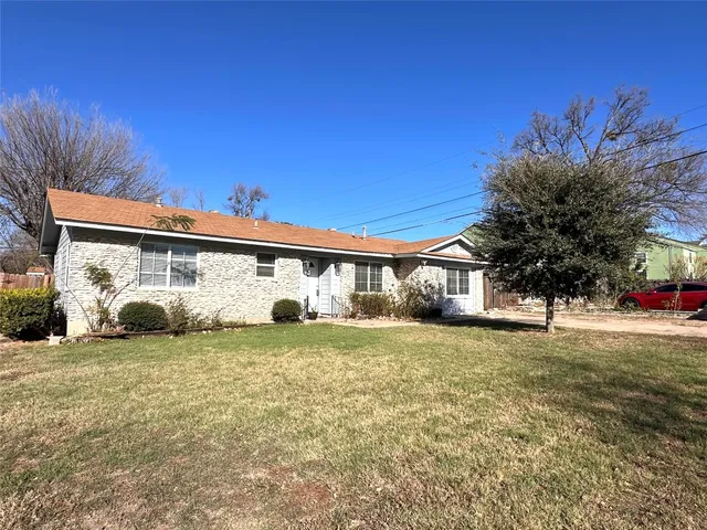 a front view of a house with a garden and yard