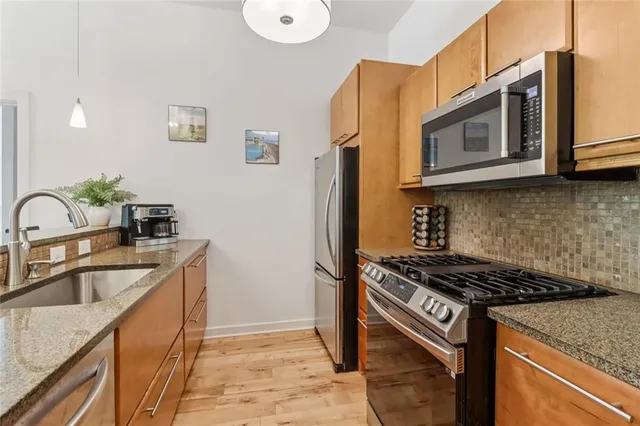 a kitchen that has a sink wooden floor and a counter top space