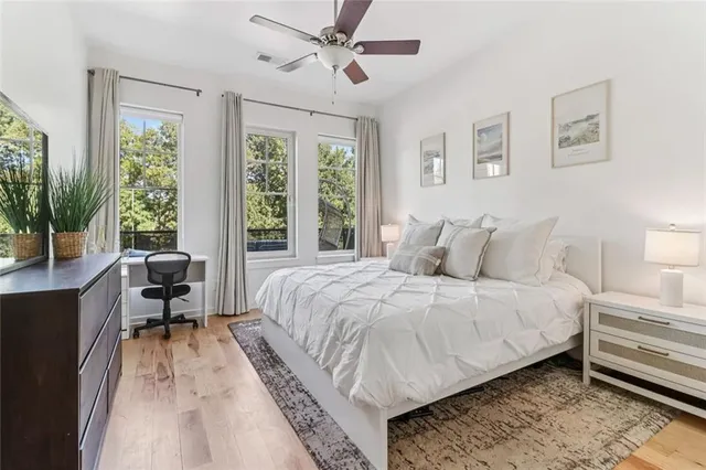 a bedroom with a bed couch and a large window