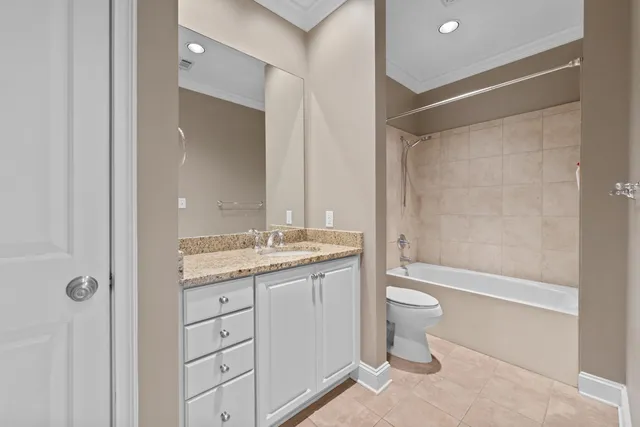a bathroom with a granite countertop sink a toilet and shower
