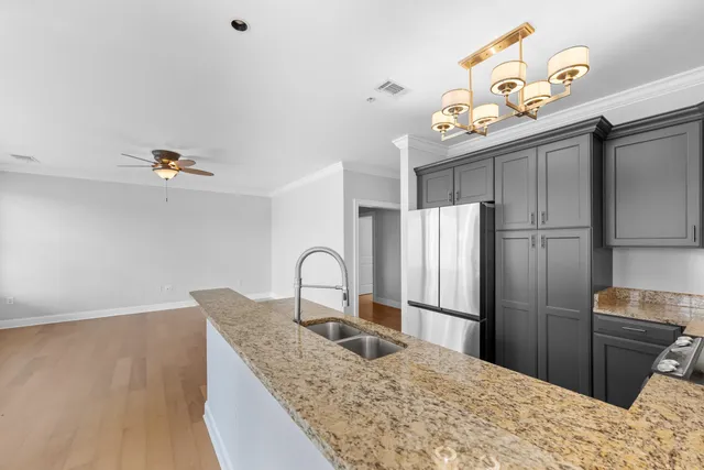 a kitchen with granite countertop a refrigerator and a sink