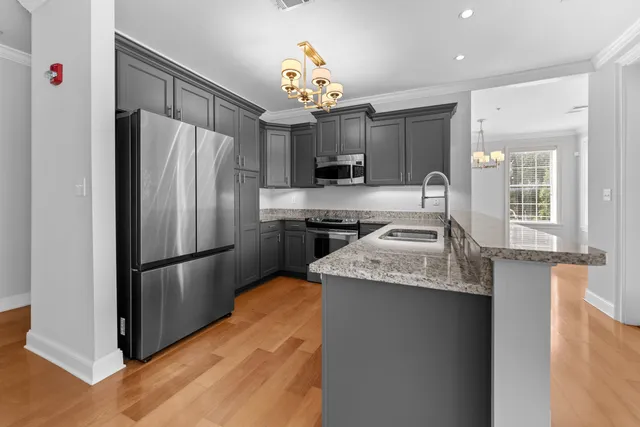 a kitchen with granite countertop stainless steel appliances a refrigerator and a sink