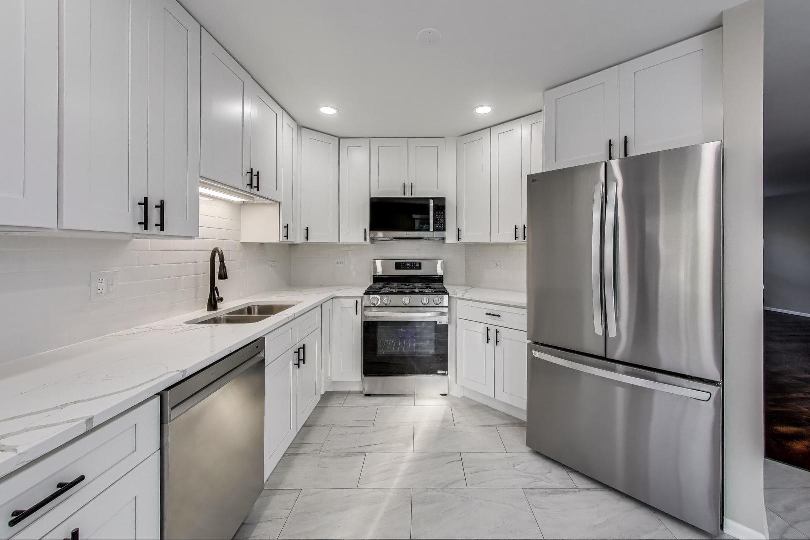 926 South W Avenue Waukegan, IL 60085 - Photo 11 of 45 a kitchen with a refrigerator sink and microwave