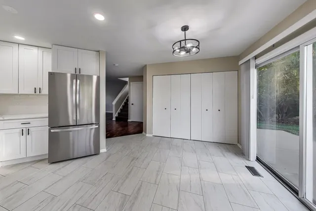 a view of a kitchen with a refrigerator a microwave and a sink