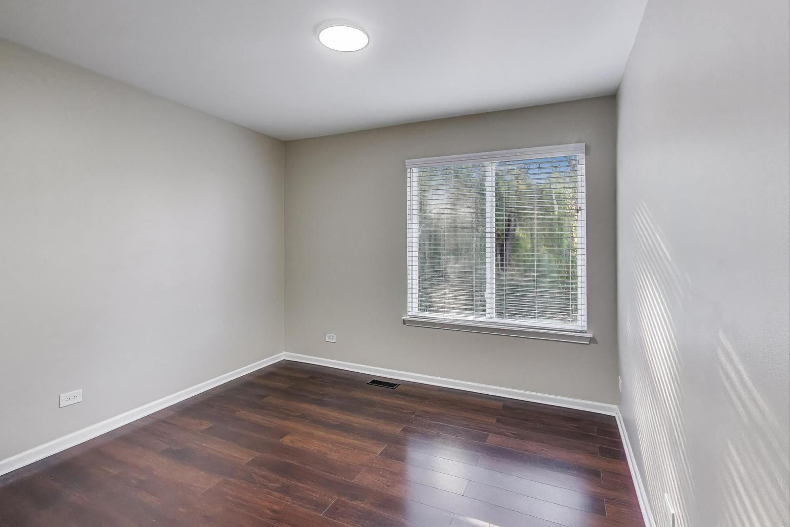 926 South W Avenue Waukegan, IL 60085 - Photo 21 of 45 an empty room with wooden floor and windows