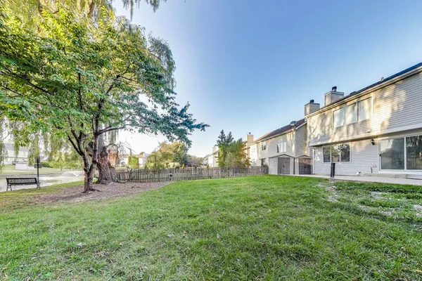 a view of a house with a big yard and large trees