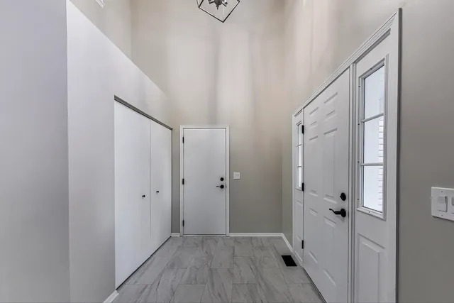 a view of a hallway with wooden floor and entryway
