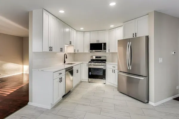a kitchen with stainless steel appliances granite countertop a refrigerator sink and stove