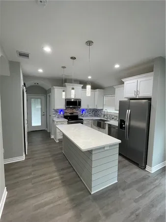 a kitchen with stainless steel appliances a stove refrigerator and a fireplace