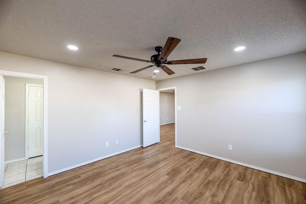 6536 7th Street Lubbock, TX 79416 - Photo 12 of 23 a view of a livingroom with a ceiling fan & wooden floor