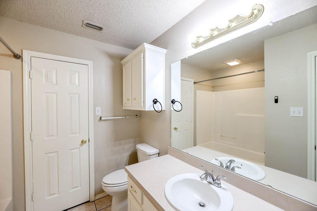 6536 7th Street Lubbock, TX 79416 - Photo 14 of 23 a bathroom with a sink a toilet and shower