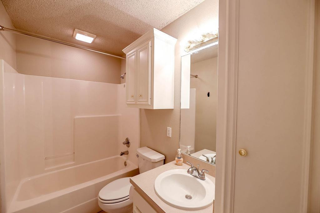 6536 7th Street Lubbock, TX 79416 - Photo 18 of 23 a bathroom with a bathtub shower sink vanity mirror and toilet