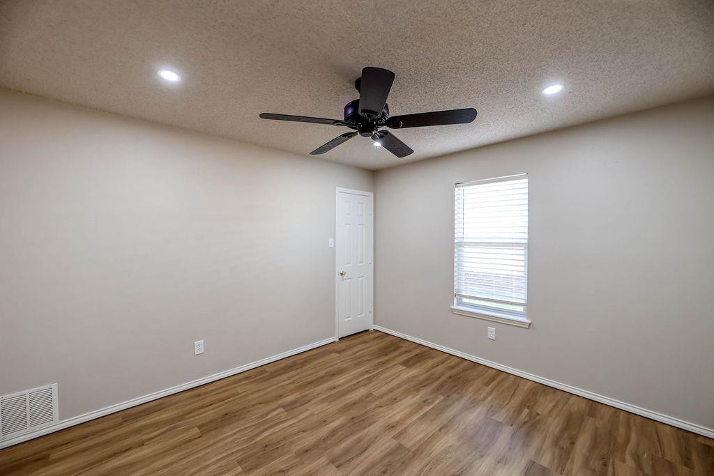6536 7th Street Lubbock, TX 79416 - Photo 19 of 23 a view of empty room with wooden floor and fan