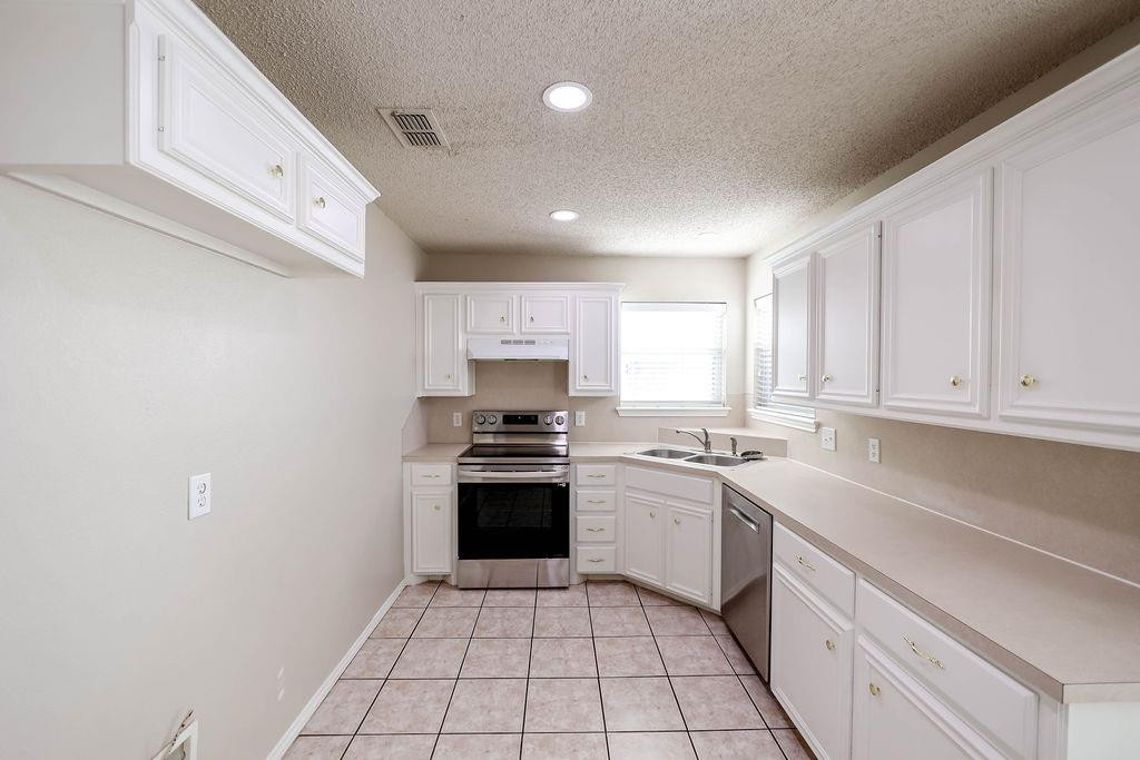 6536 7th Street Lubbock, TX 79416 - Photo 6 of 23 a kitchen with stainless steel appliances granite countertop a sink and stove top oven