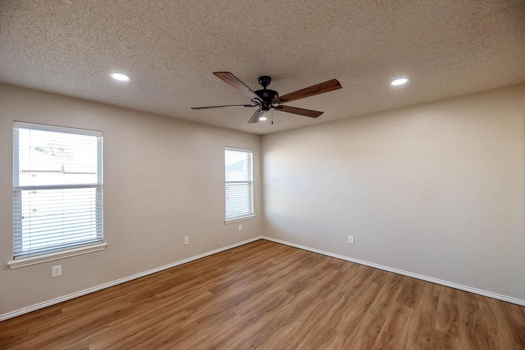 6536 7th Street Lubbock, TX 79416 - Photo 10 of 23 a view of empty room with wooden floor and fan