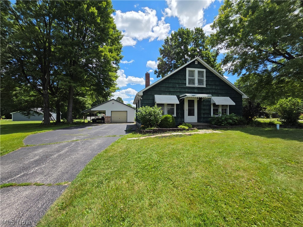 2335 West River Road Newton Falls, OH 44444 - Photo 1 of 36 Green siding exterior with white window awnings and a prominent front door