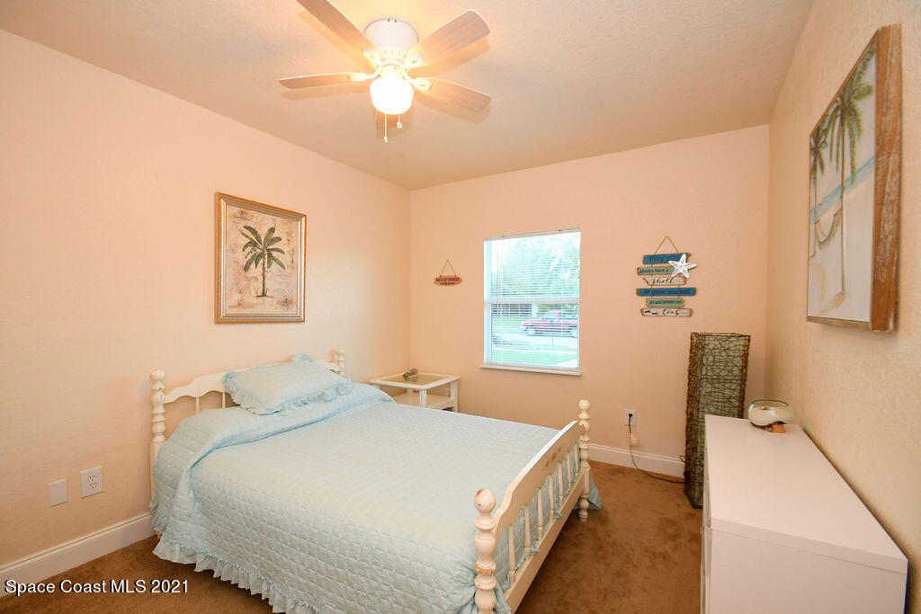 1461 Creel Road Northeast Palm Bay, FL 32905 - Photo 11 of 20 a bedroom with a bed and a chandelier