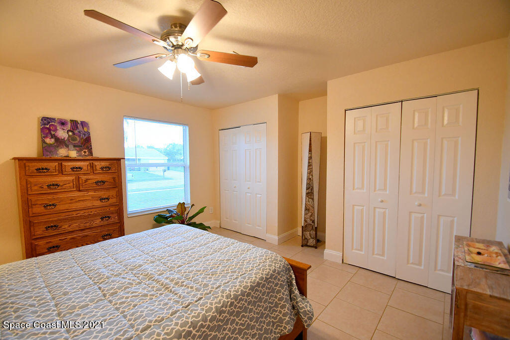 1461 Creel Road Northeast Palm Bay, FL 32905 - Photo 14 of 20 a bedroom with a bed and a chandelier