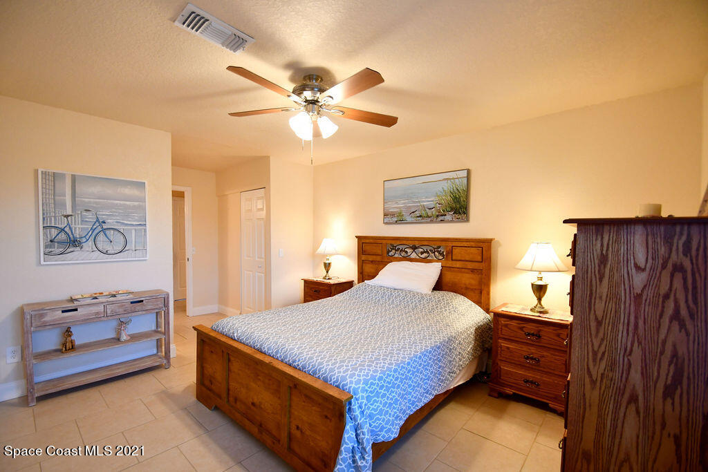 1461 Creel Road Northeast Palm Bay, FL 32905 - Photo 15 of 20 a bedroom with a bed and a chandelier