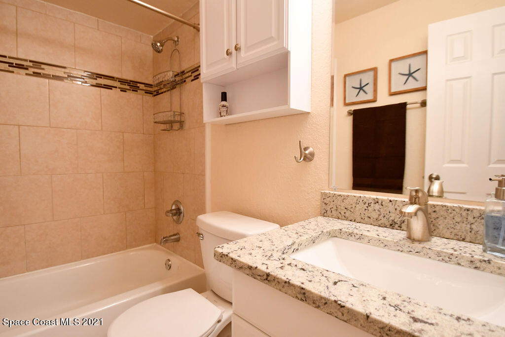1461 Creel Road Northeast Palm Bay, FL 32905 - Photo 16 of 20 a bathroom with a granite countertop tub sink toilet and shower