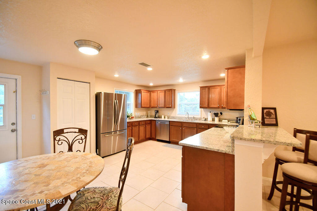 1461 Creel Road Northeast Palm Bay, FL 32905 - Photo 4 of 20 a kitchen with stainless steel appliances kitchen island granite countertop a refrigerator and a sink