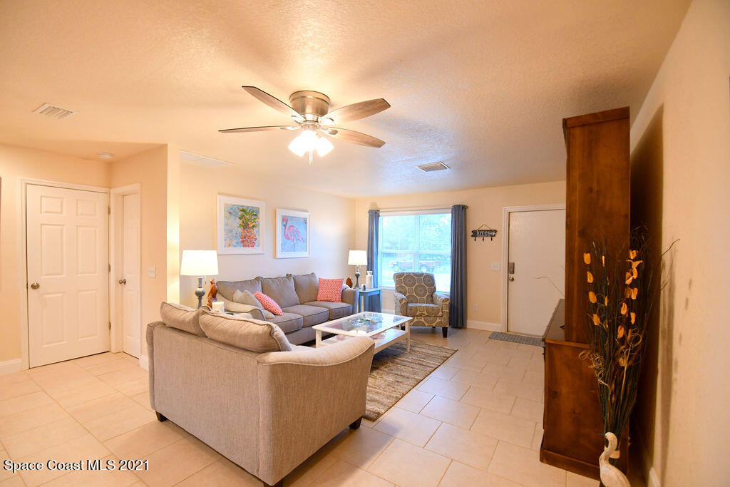 1461 Creel Road Northeast Palm Bay, FL 32905 - Photo 9 of 20 a living room with furniture and a chandelier