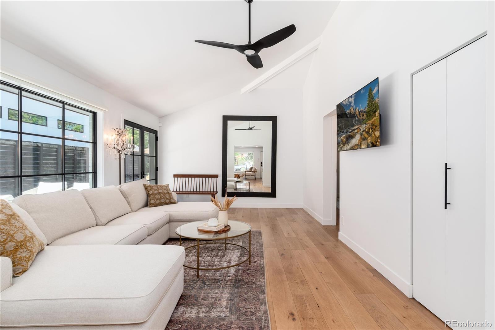 1065 South Monroe Street Denver, CO 80209 - Photo 11 of 32 a living room with furniture a flat screen tv and a large window