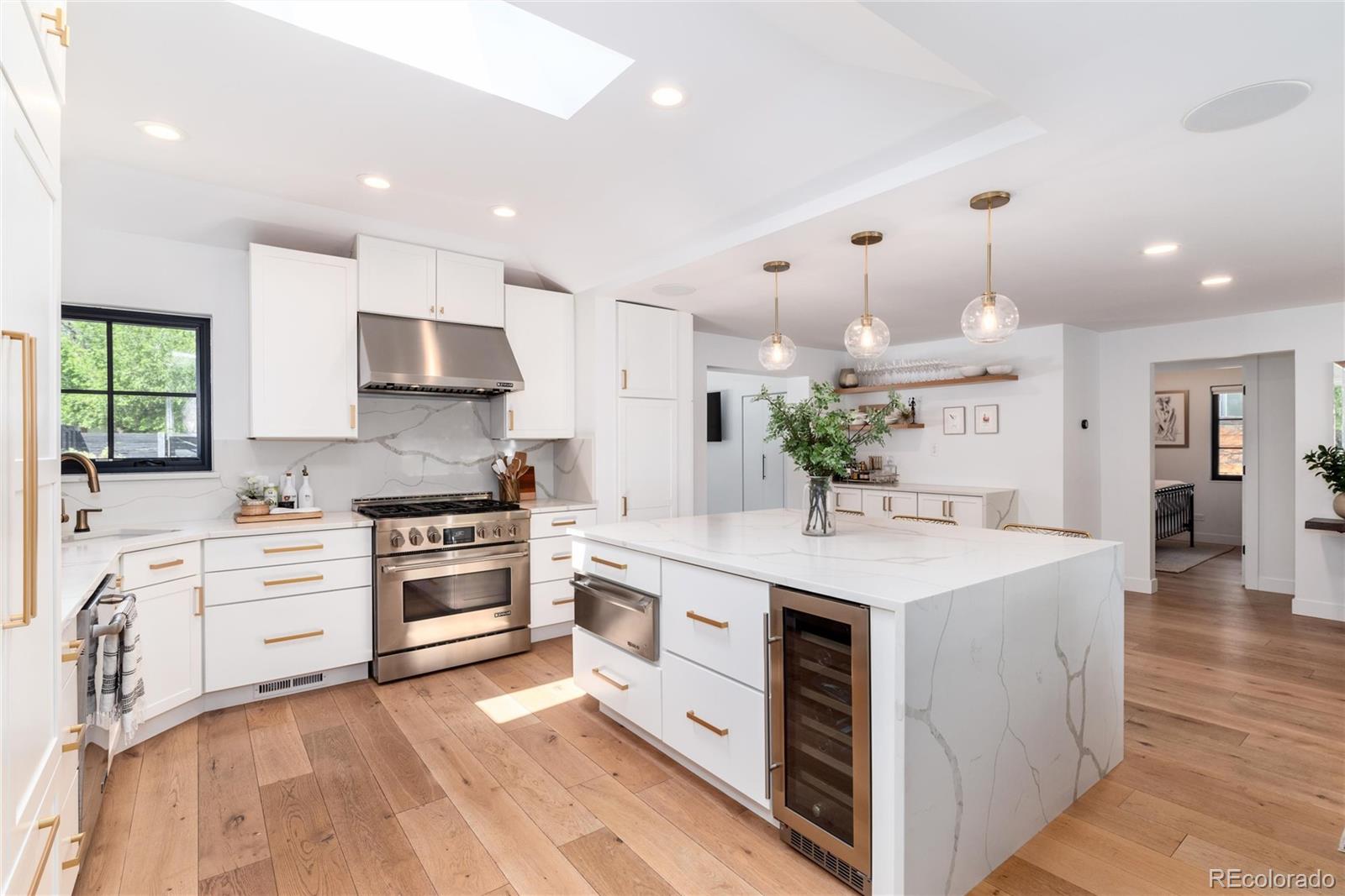 1065 South Monroe Street Denver, CO 80209 - Photo 4 of 32 a kitchen with kitchen island granite countertop a white stove top oven and cabinets