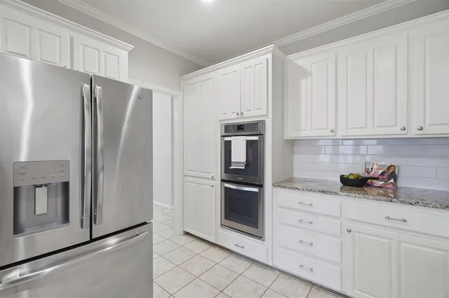 a kitchen with white cabinets and stainless steel appliances