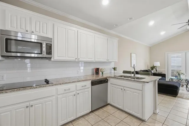 a kitchen with granite countertop white cabinets white stainless steel appliances with a sink and dishwasher