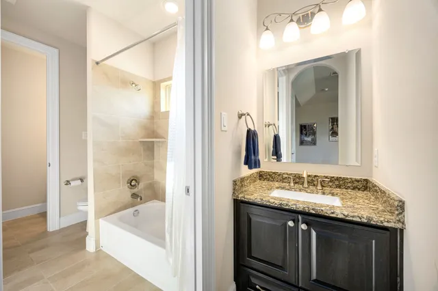 a bathroom with a granite countertop sink tub and mirror
