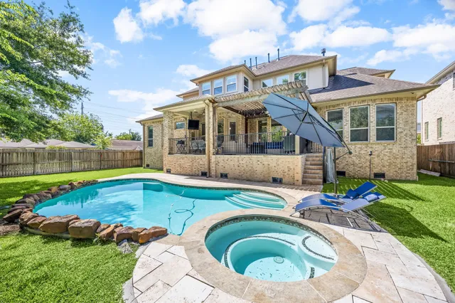 a view of a house with swimming pool and yard