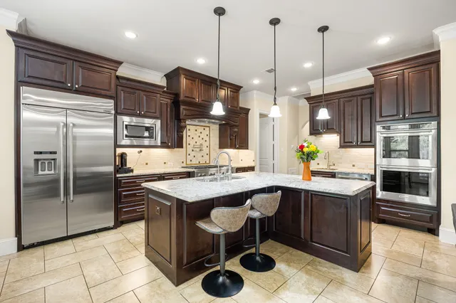 a kitchen with stainless steel appliances granite countertop a sink and a refrigerator