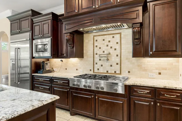 a kitchen with granite countertop stainless steel appliances and wooden cabinets