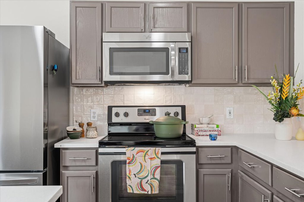 7451 Pusch Ridge Loop Austin, TX 78749 - Photo 12 of 26 Modern cabinetry and stone countertops frame the stainless steel appliances in this functional workspace.