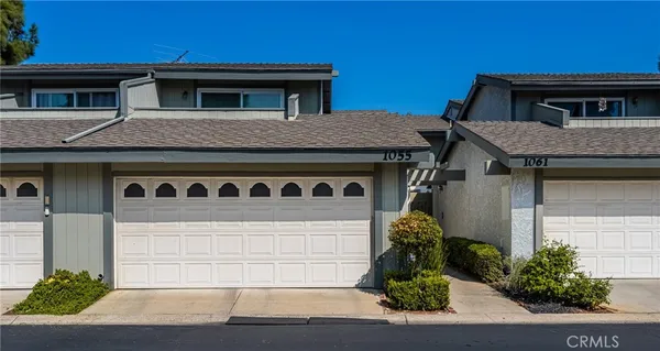a front view of a house with potted plants