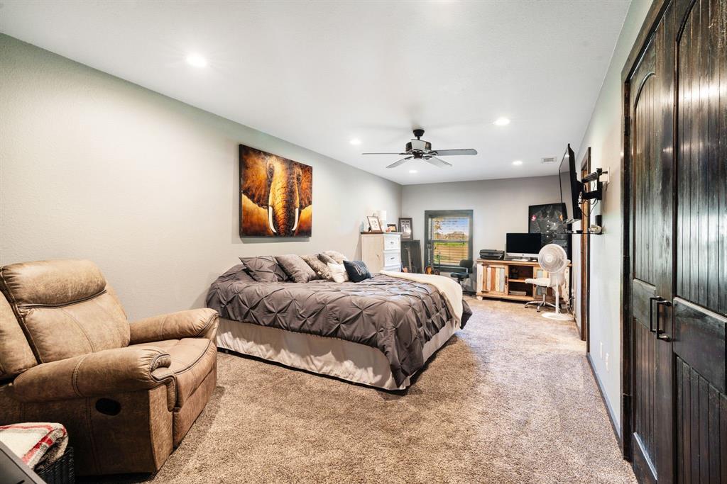 962 County Road Pattonville, TX 75468 - Photo 29 of 37 a spacious bedroom with a bed couch chandelier and a window
