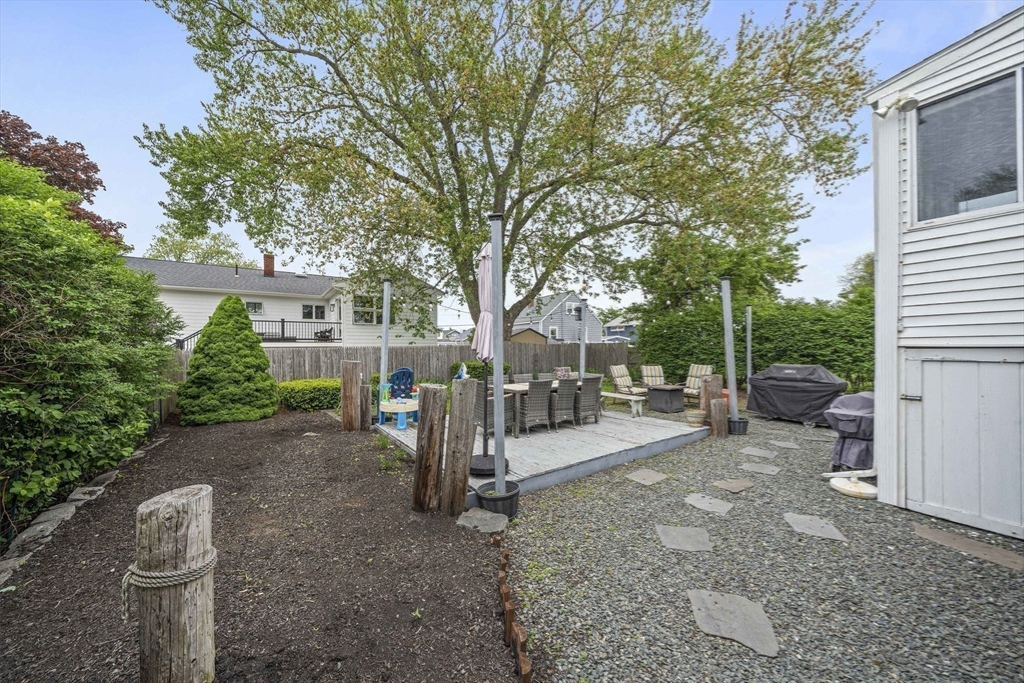 15 D Street Hull, MA 02045 - Photo 23 of 42 a view of a backyard with a table and chairs under an umbrella