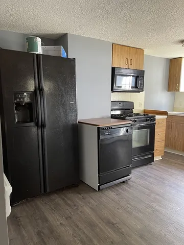 a kitchen with stainless steel appliances granite countertop a refrigerator stove and sink