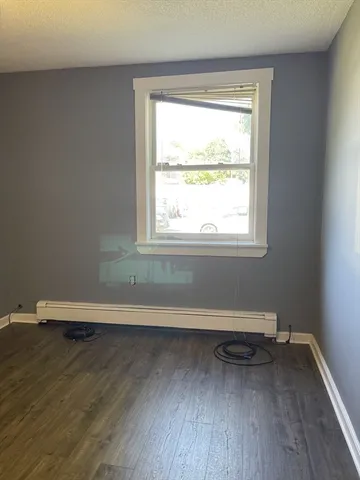 a view of a room with wooden floor and a window