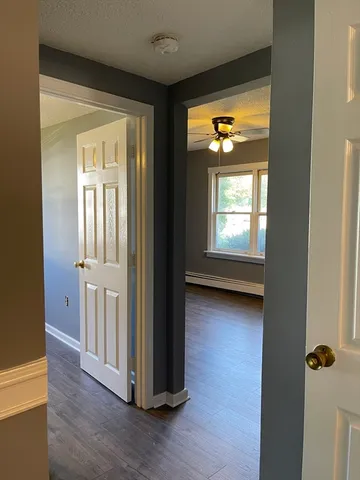 a view of a hallway with wooden floor and windows