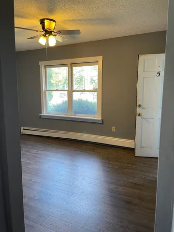 an empty room with wooden floor and a window