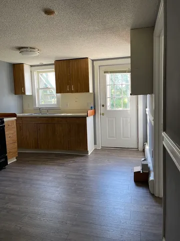 a view of a kitchen with a sink dishwasher oven window and wooden floor