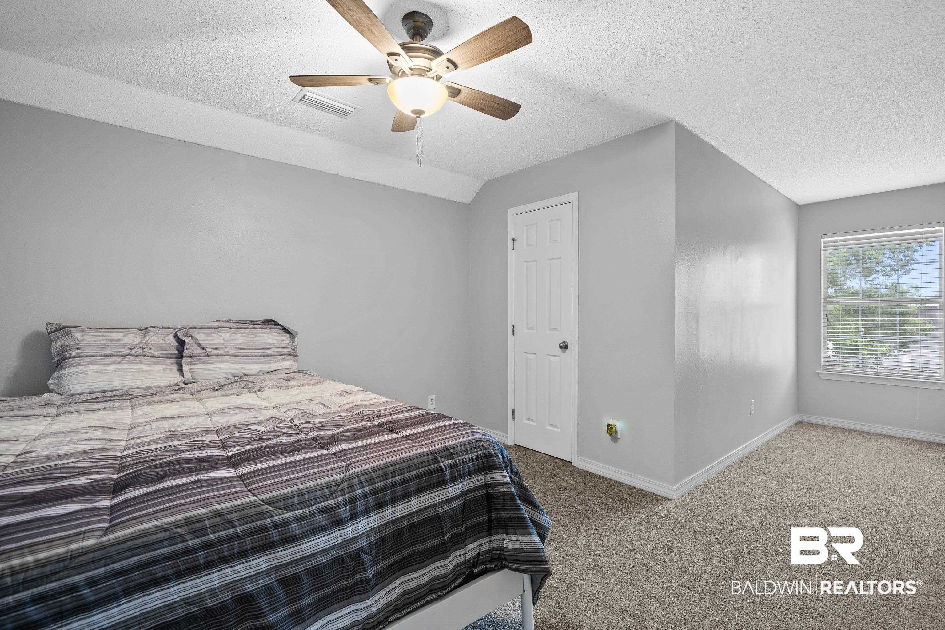 9552 Collier Loop Daphne, AL 36526 - Photo 22 of 28 Bedroom with carpet floors, a textured ceiling, baseboards, a ceiling fan, and vaulted ceiling