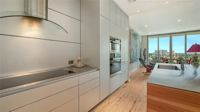 a kitchen with stainless steel appliances granite countertop a sink and a refrigerator