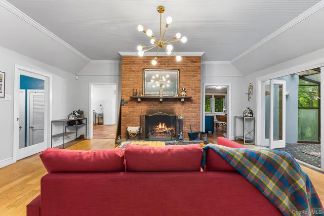 a living room with furniture a fireplace and a chandelier