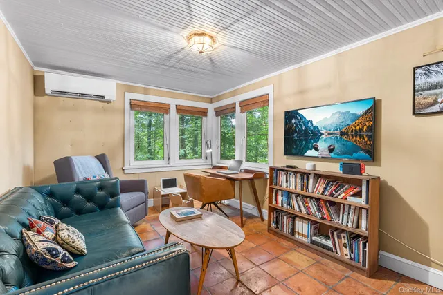a living room with furniture a bookshelf and a window
