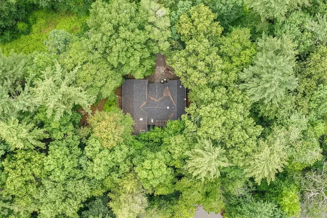 an aerial view of a house with a yard and large tree