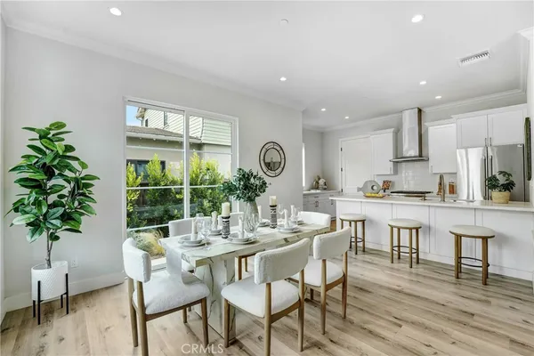 a dining room with furniture potted plants and wooden floor