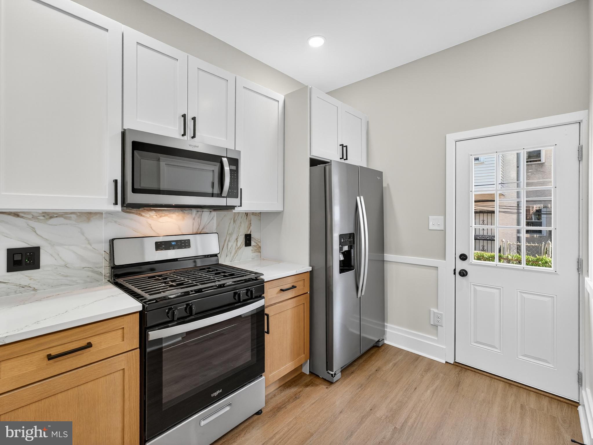 5736 Spruce Street Philadelphia, PA 19139 - Photo 5 of 32 a kitchen with cabinets stainless steel appliances and wooden floor